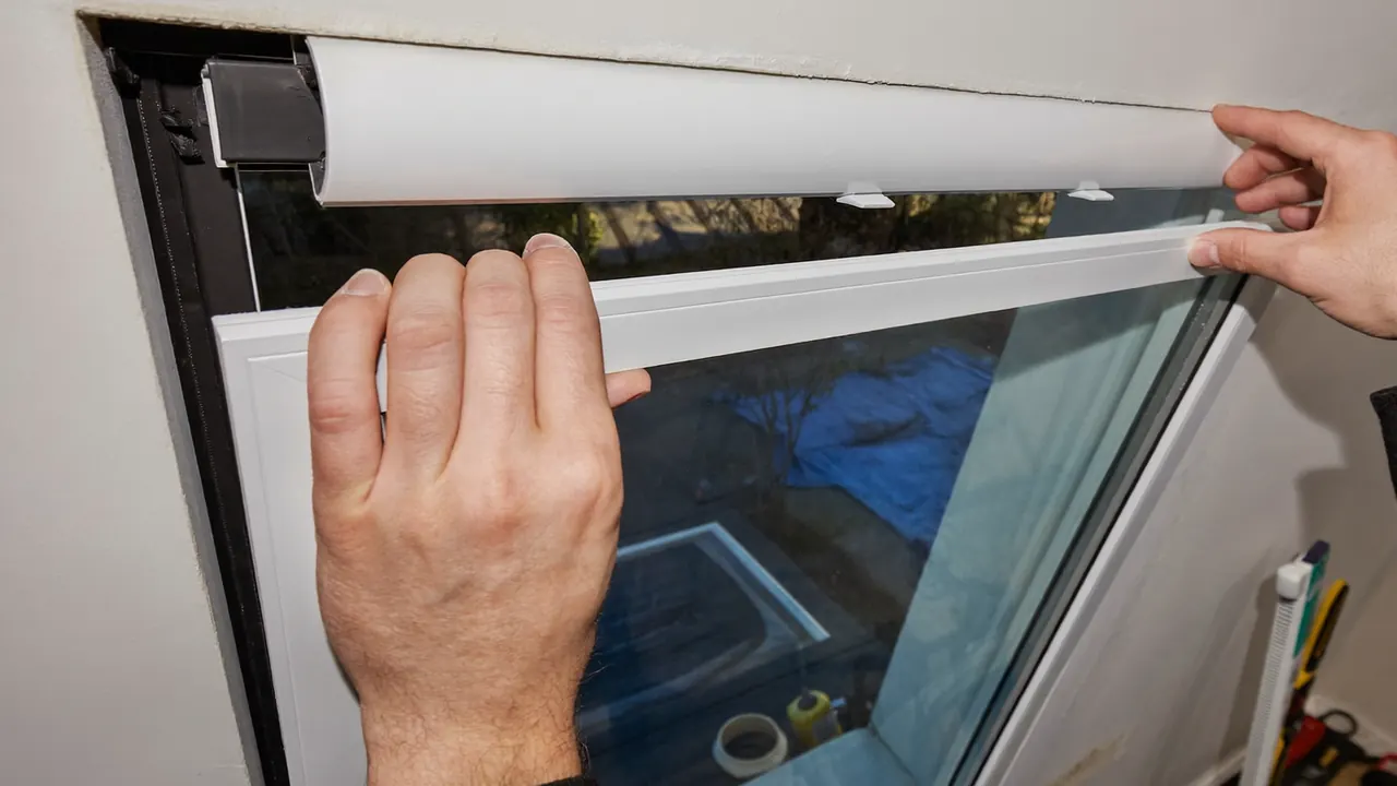 An installer fitting an A-rated replacement window into a masonry opening