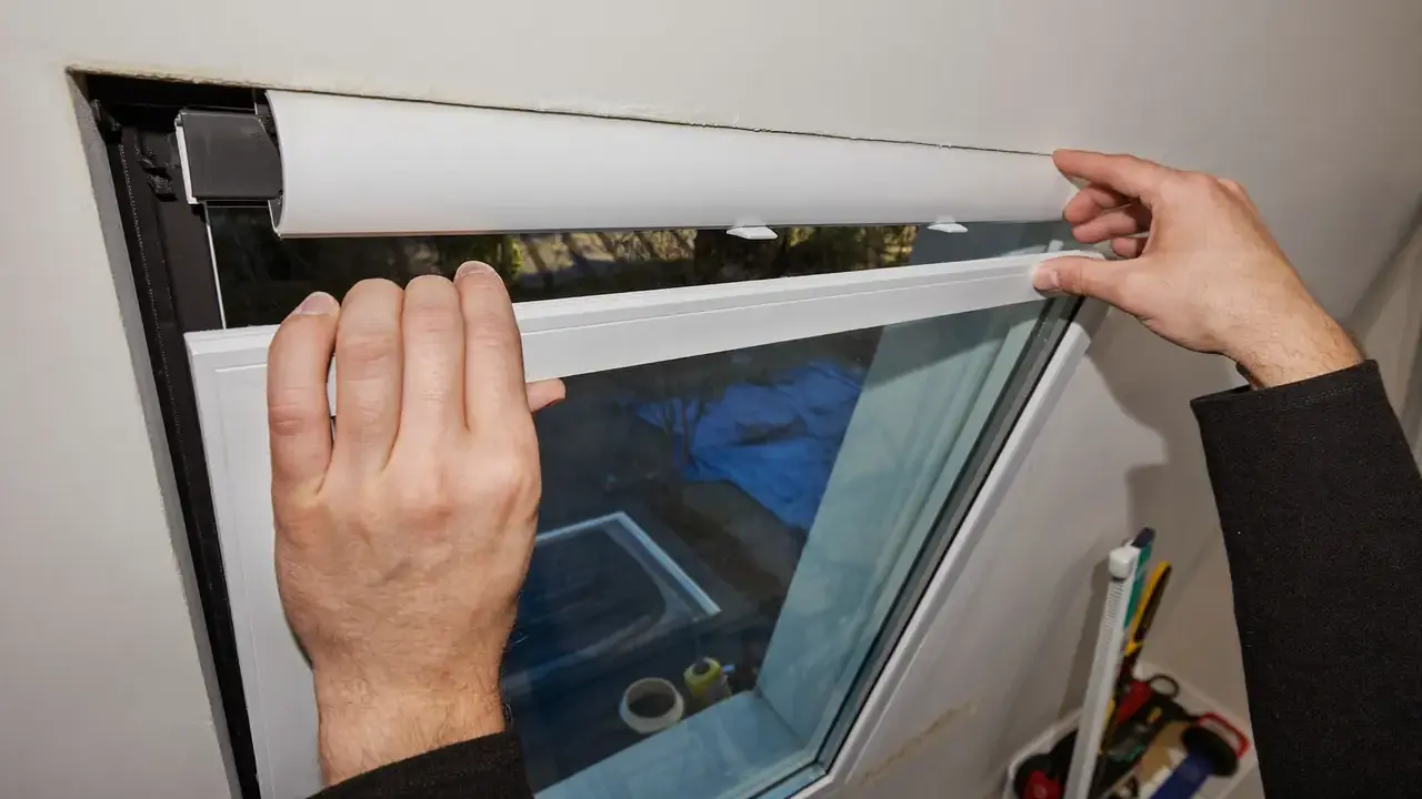 An installer fitting a reinforced uPVC window frame into a masonry opening