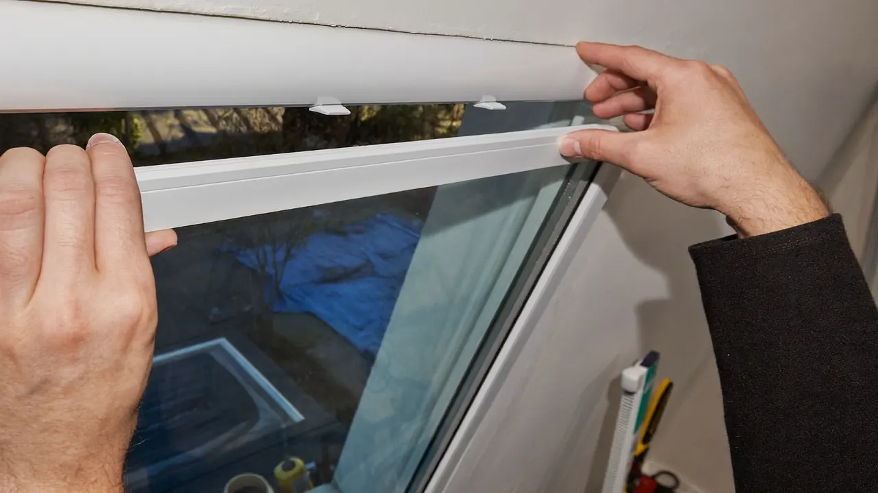 An installer handling a sealed double-glazed glass unit before fitting